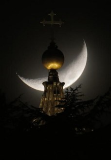 The moon is seen behind a dome of St. Peter's Basilica at the Vatican, Saturday, March 16, 2013. Province of Rome Lazio